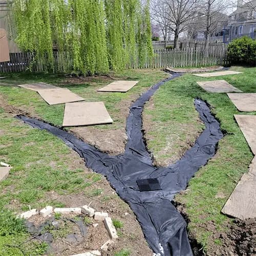 Closed French Drain System with filter fabric wrapping to prevent clogging and ensure long-term drainage performance